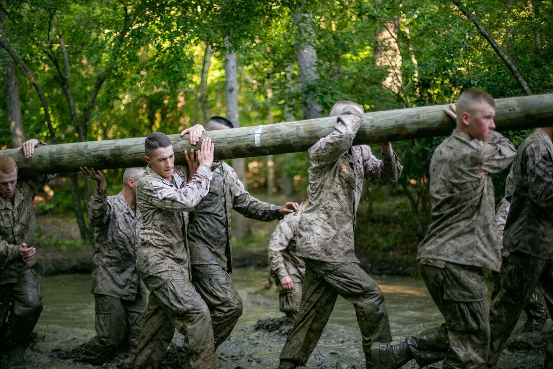Candidates from conduct Montford Point Challenge (MPC) carrying (3) 40mm ammo cans, a stretcher with (3) 75lbs sandbags, and a log.  MPC includes a combination of 3 courses; Juniors Stamina Course, Senior Stamina Course, and a portion of the Combat Course.  The purpose of the MPC is to Honor and Celebrate the selfless sacrifice and heroism of the Montford Point Marines.  (U.S. Marine Corps photo by Sgt Gumchol Cho)