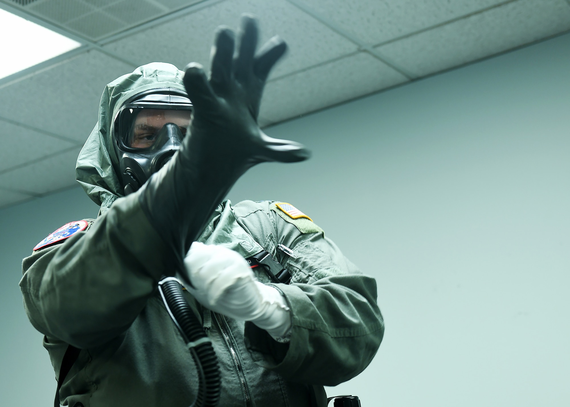 Airman in MOPP gear putting on protective glove