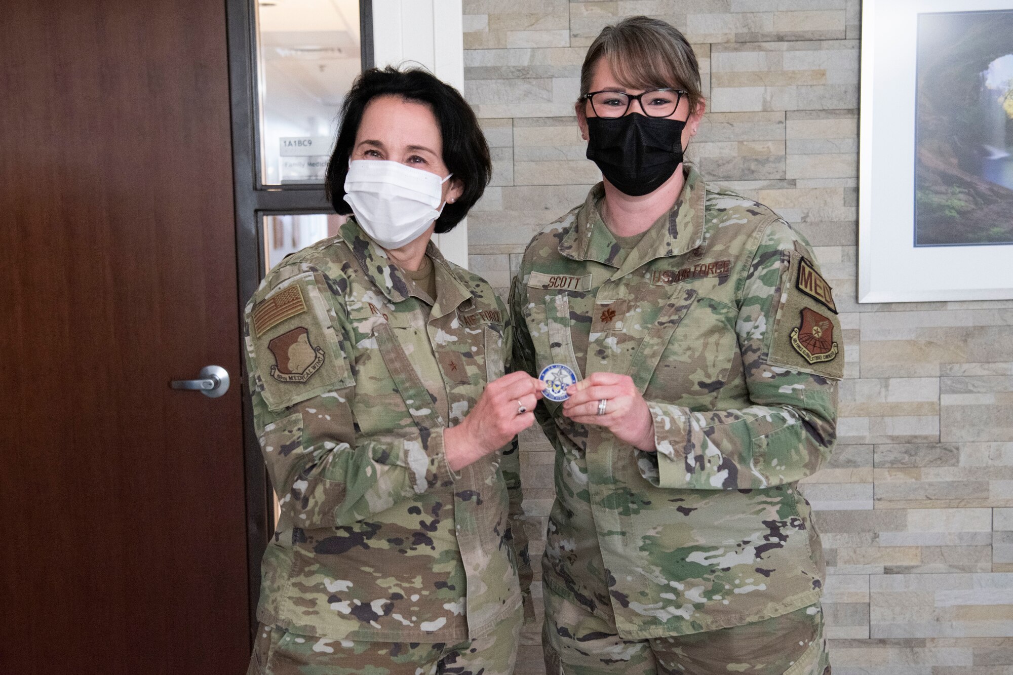 Brig. Gen. Jeannine Ryder, 59th Medical Wing commander and chief of the Air Force Nurse Corps, coins Maj. Anne Scott, 7th Medical Group medical services flight commander, at Dyess Air Force Base, Texas, February 22, 2023. Ryder and Chief Master Sgt. Taliah Wilkerson, Air Force Readiness Agency's Aerospace Medical Service and Surgical Service Career Field Manager, provided a strategic overview and future posture of the Total Nursing Force at the 7th MDG, while also learning about the different mission sets by the Airmen. (U.S. Air Force photo by Airman 1st Class Alondra Cristobal Hernandez)