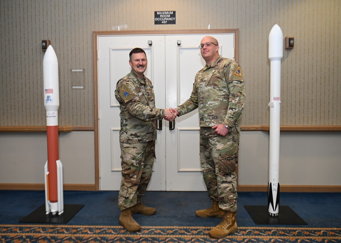 U.S. Space Force Chief Master Sgt. Heath Jennings, Space Launch Delta 30 Senior Enlisted Leader, poses with U.S. Air Force Master Sgt. Bond Aulik, Space Launch Delta 30 career advisor, at the Pacific Coast Club on Vandenberg Space Force Base, Calif., Feb. 23, 2023. Master Sgt. Aulik was coined for his countless hours he has dedicated to providing tools and resources to all Airmen and Guardians at Vandenberg. (U.S. Space Force photo by Airman 1st Class Kadielle Shaw)