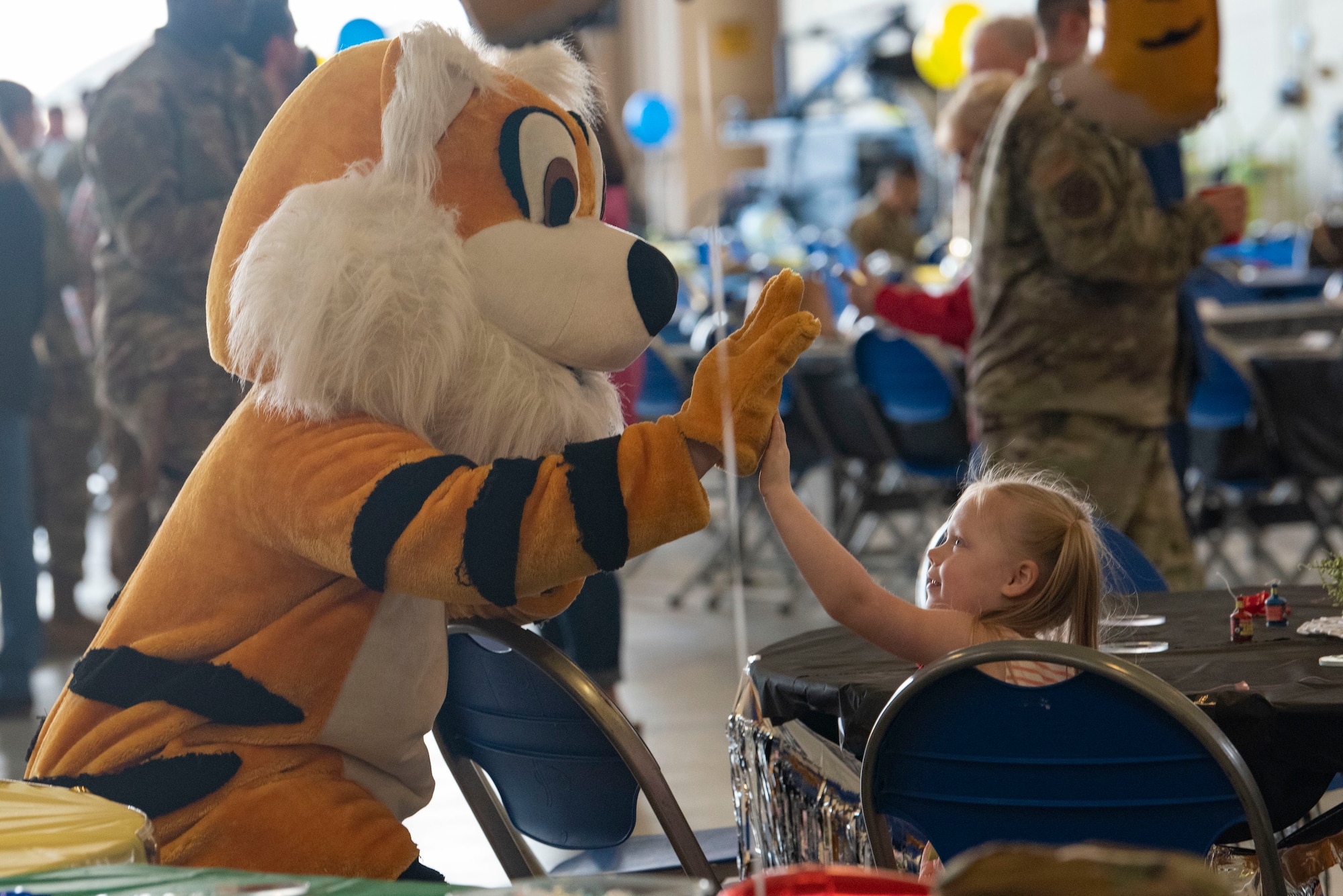 A mascot of the 23rd Wing Flying Tigers high fives a young attendee during the annual Maintenance Professional of the Year awards banquet at Moody Air Force Base, Georgia, Feb. 17, 2023. MPOY recognizes Airmen’s exceptional work, as well as the dedication and sacrifice of their families. (U.S. Air Force photo by Staff Sgt. Thomas Johns)