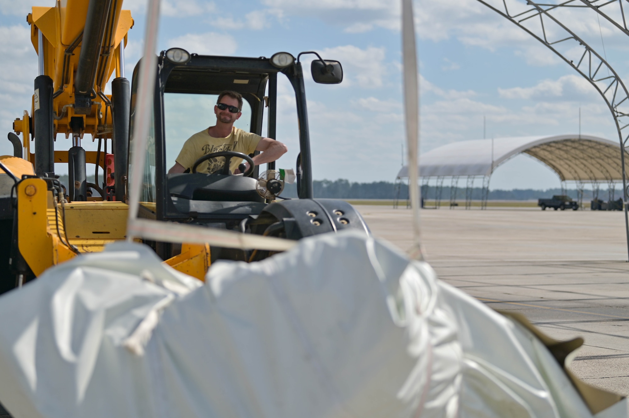 Ryan Long, Ryzing Technologies chief operations officer, lifts a bundle of fabric at Moody Air Force Base, Georgia, Feb. 16, 2023. Creative Tent International is projected to completely renovate all 52 sunshades structures, replace fabric covers, replace critical hardware, and more under a $1.5 million contract. (U.S. Air Force photo by Senior Airman Rebeckah Medeiros)