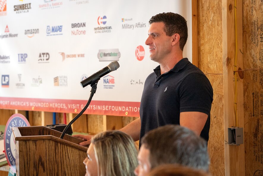 a man stands behind a podium and speaks at the microphone