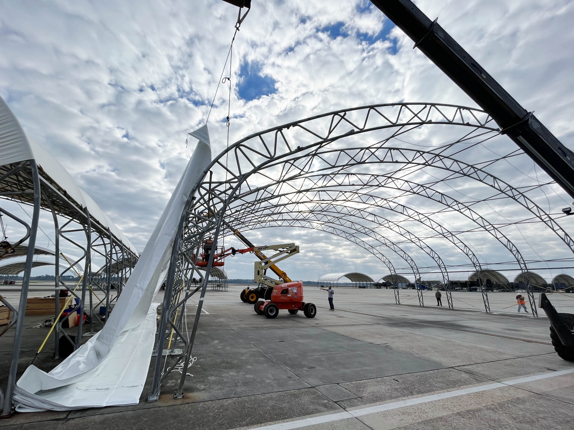 Members from Creative Tent International and Ryzing Technologies lift and fit fabric on a metal structure for A-10C Thunderbolt II sunshade renovations at Moody Air Force Base, Georgia, Feb. 16, 2023. Current fabric canopy covers last approximately 10 years; however, the upgraded fabric is projected to last twice as long. (U.S. Air Force courtesy photo)