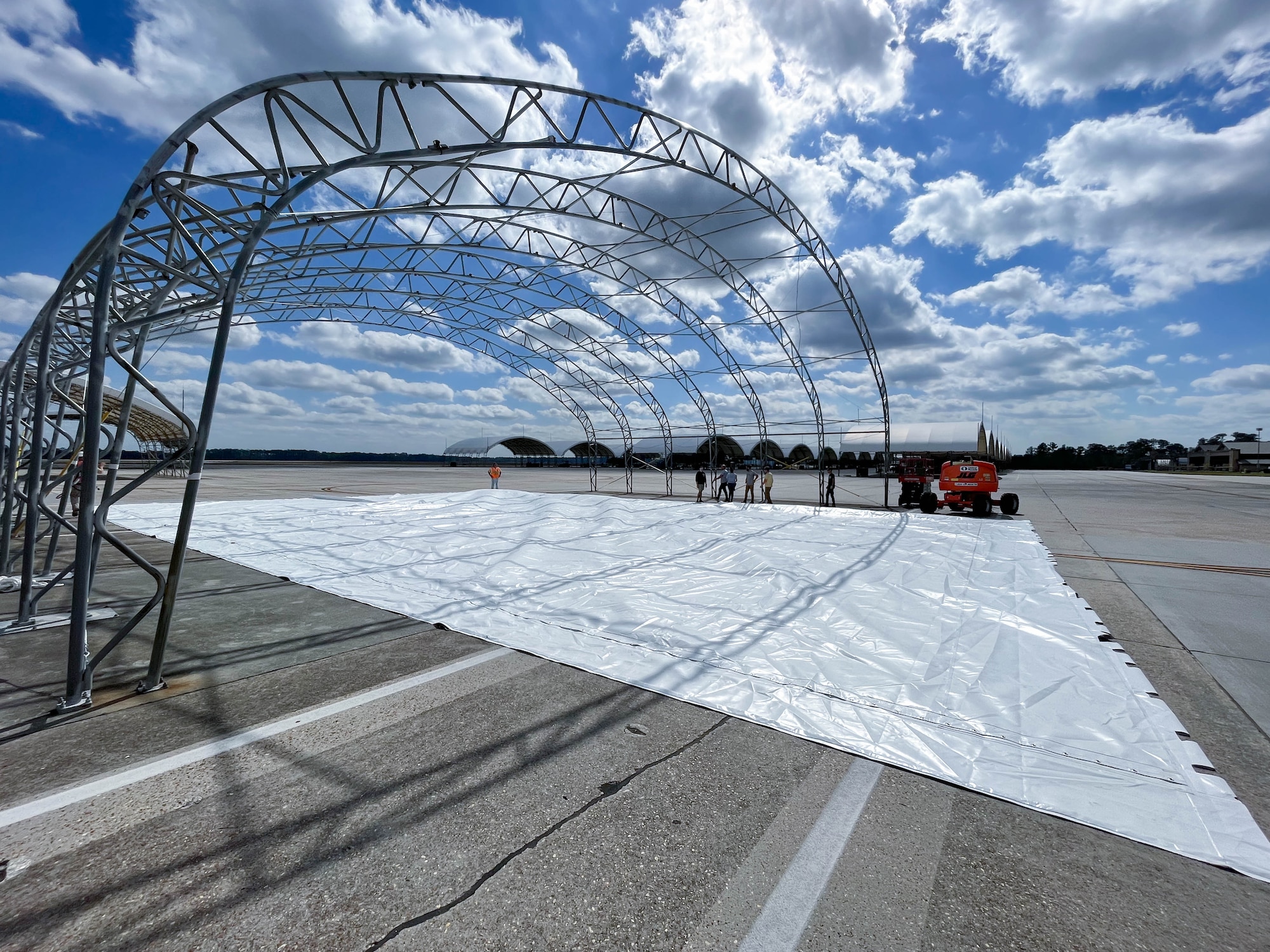 Members from Creative Tent International and Ryzing Technologies unroll fabric for A-10C Thunderbolt II sunshade renovations at Moody Air Force Base, Georgia, Feb. 16, 2023. The fabric covers last approximately 10 years; however, the new fabric is projected to double the lifespan. (U.S. Air Force courtesy photo)
