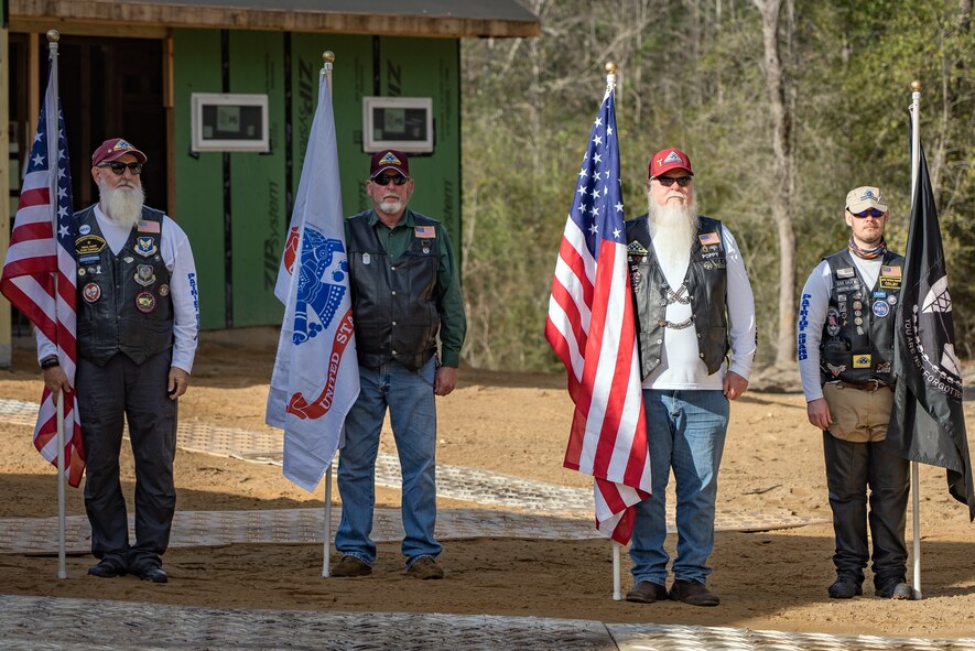 Veterans stand with their flags outside of a building