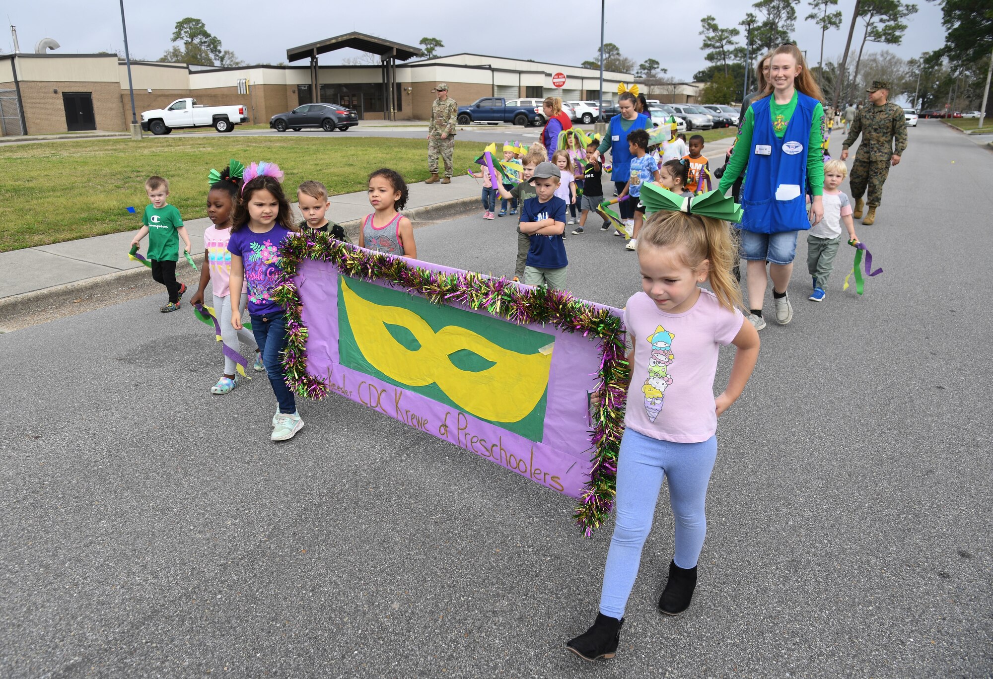 Personnel and children from the Keesler Child Development Center participate in a Mardi Gras parade at Keesler Air Force Base, Mississippi, Feb. 21, 2023.