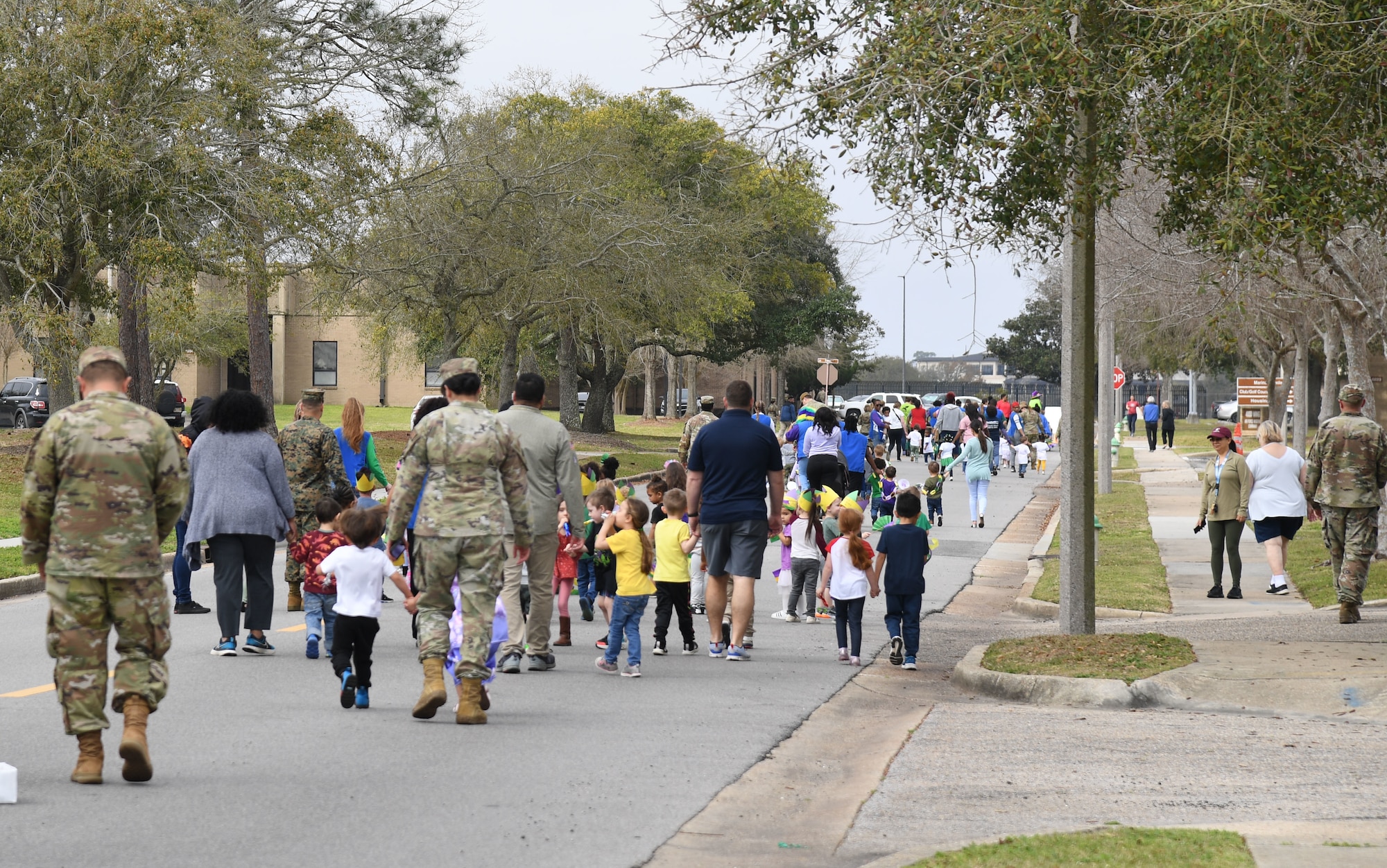Keesler personnel and children from the Keesler Child Development Center participate in a Mardi Gras parade at Keesler Air Force Base, Mississippi, Feb. 21, 2023.