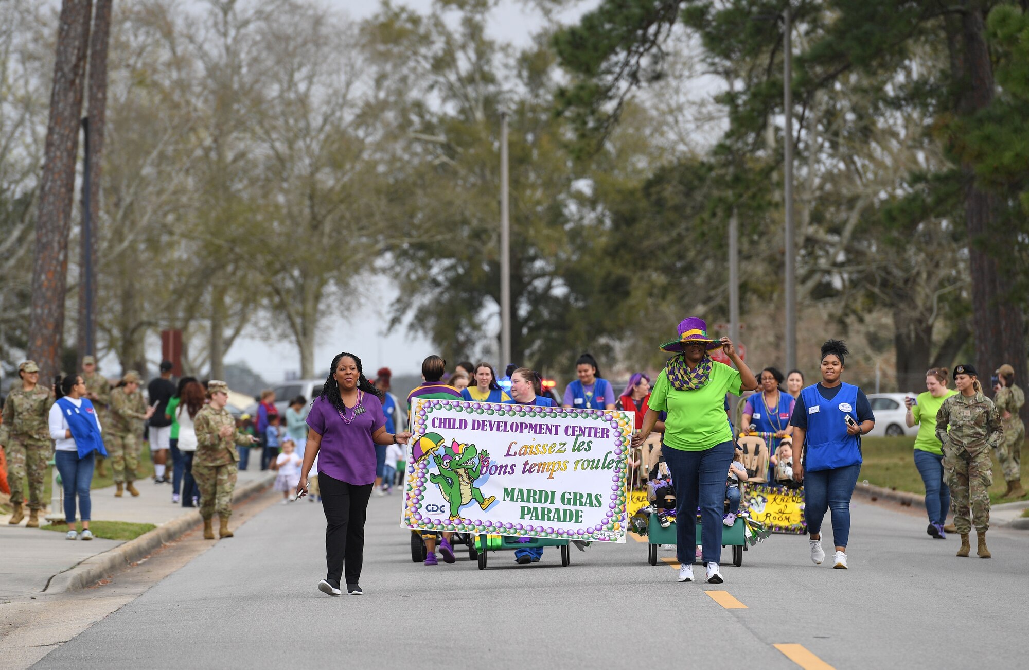 Personnel and children from the Keesler Child Development Center participate in a Mardi Gras parade at Keesler Air Force Base, Mississippi, Feb. 21, 2023.