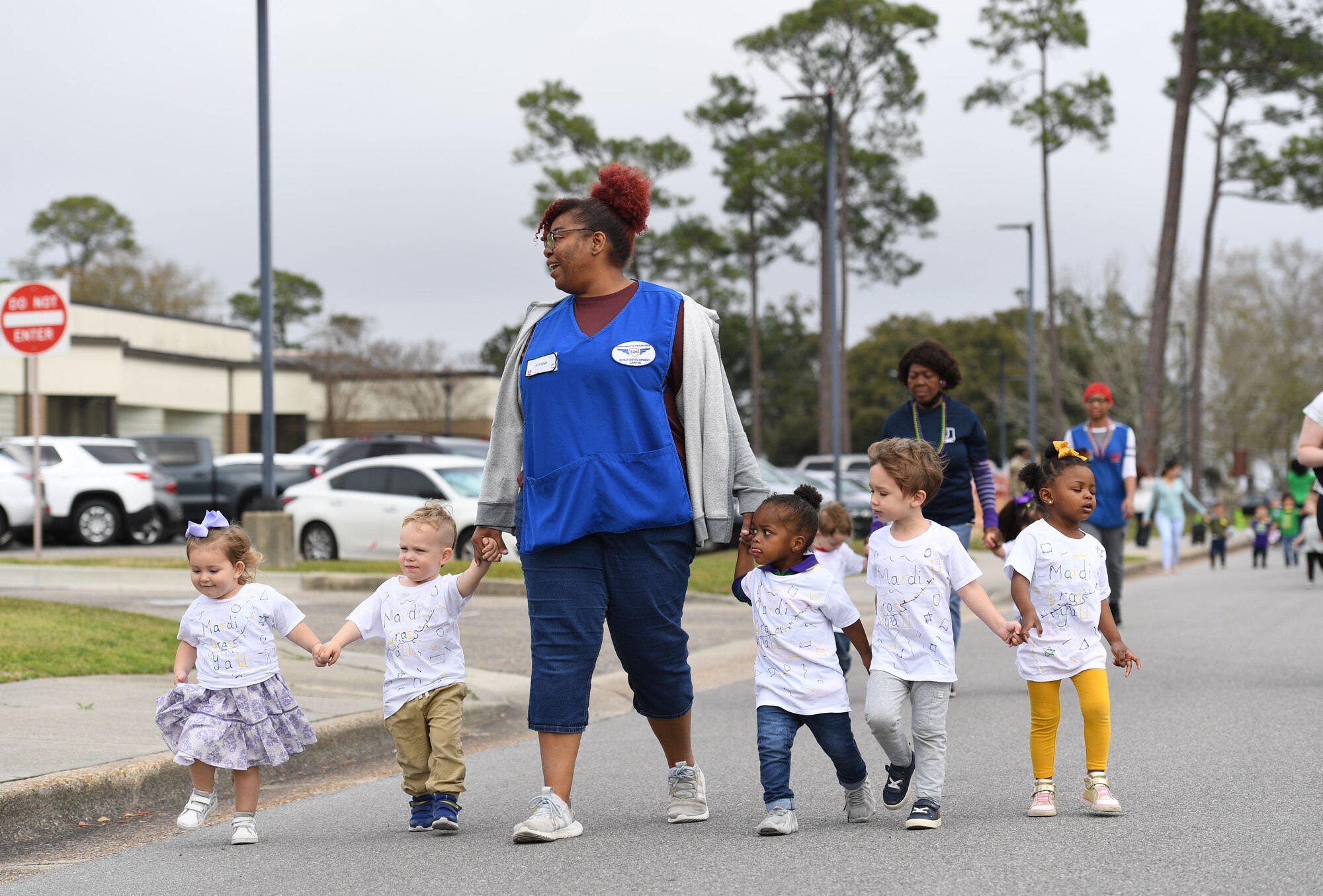 Personnel and children from the Keesler Child Development Center participate in a Mardi Gras parade at Keesler Air Force Base, Mississippi, Feb. 21, 2023.