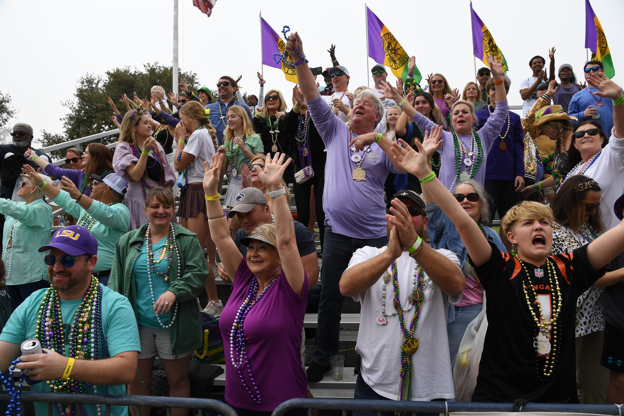 Parade attendees raise their hands and shout for bead throws from floats during the Gulf Coast Carnival Association Mardi Gras parade in Biloxi, Mississippi, Feb. 21, 2023.