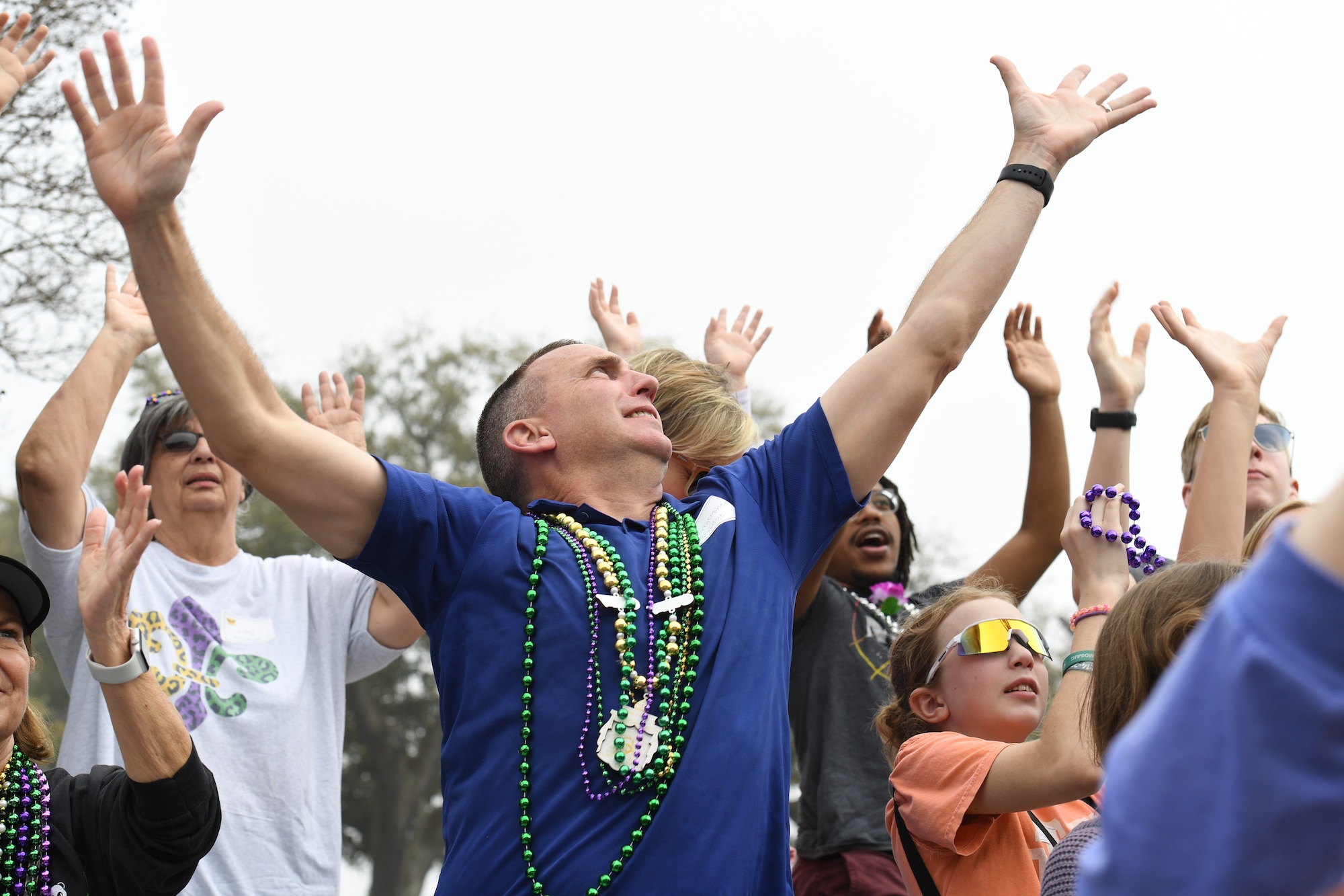 U.S. Air Force Col. Christopher Estridge, 81st Medical Group commander, reaches for bead necklaces tossed to him from floats during the Gulf Coast Carnival Association Mardi Gras parade in Biloxi, Mississippi, Feb. 21, 2023.