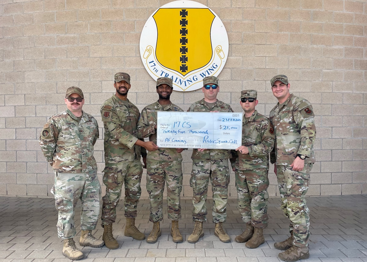 U.S. Air Force Tech. Sgt. Justin Crook, 17th Training Wing Raider Spark Cell section chief, far left, and Master Sgt. Anthony Lefemine, 17TRW RSC superintendent, far right, award Air and Space Force Gaming $25,000 from squadron innovation funds, Goodfellow Air Force Base, Texas, March 23, 2023. The RSC awarded eight projects a total of $450,000. (U.S. Air Force photo by Staff Sgt. Abbey Rieves)