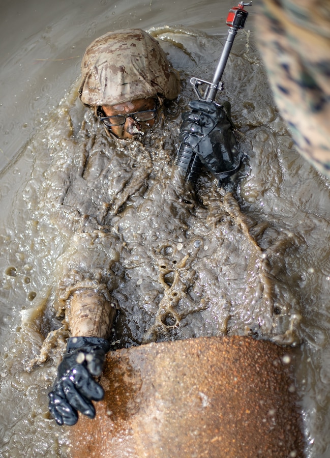 Candidates from Co. A and D, OCC-242, conduct the Combat Course. The Combat Course provides an austere environment littered with obstacles in which the candidates must negotiate with their fire team. The tactical skills emphasized include use of cover and concealment, fire team movement, and security. (U.S. Marine Corps photo by Sgt Gumchol Cho)