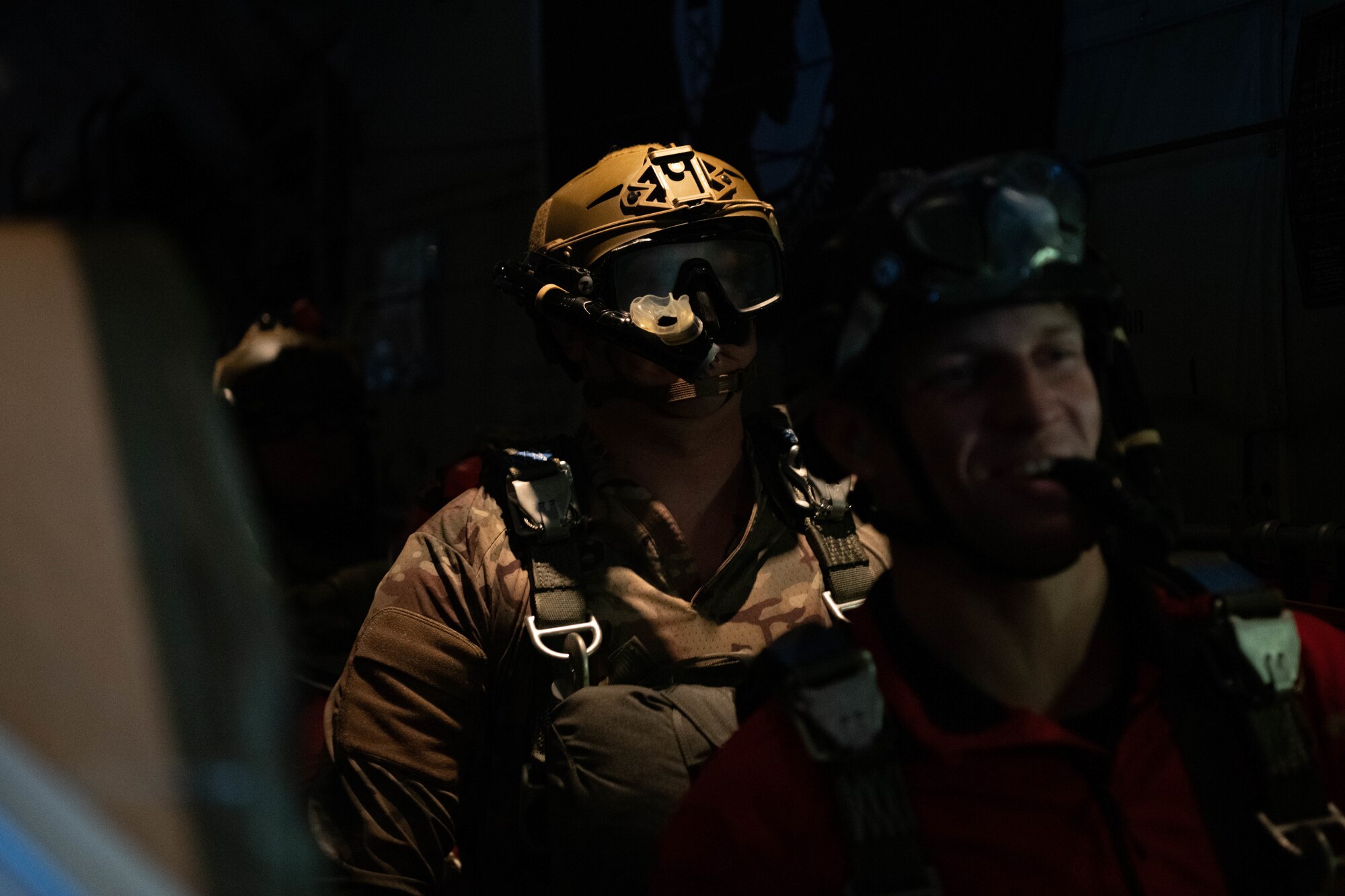 Airmen prepare to jump from an aircraft.