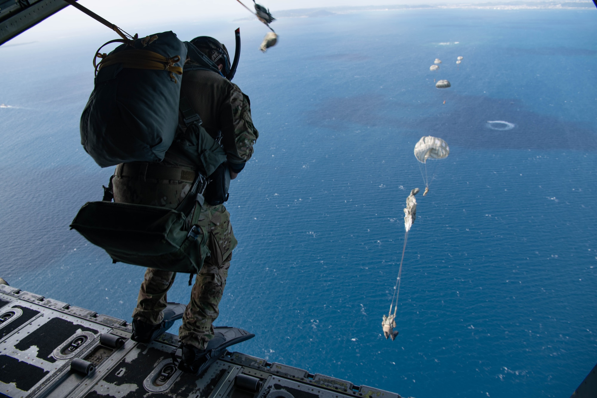 Airmen jump out of an aircraft.