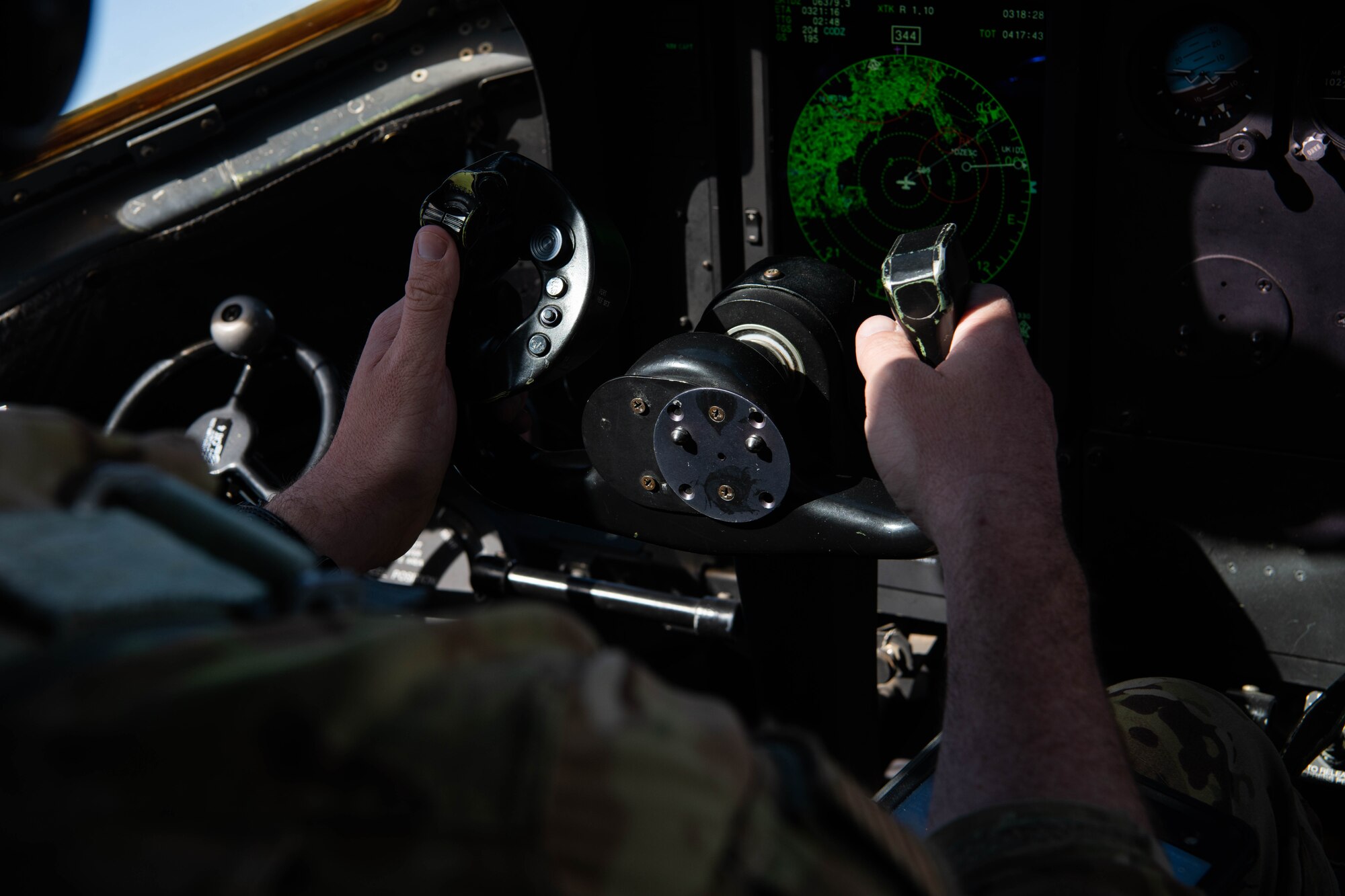 An Airman holds the controls of an aircraft.