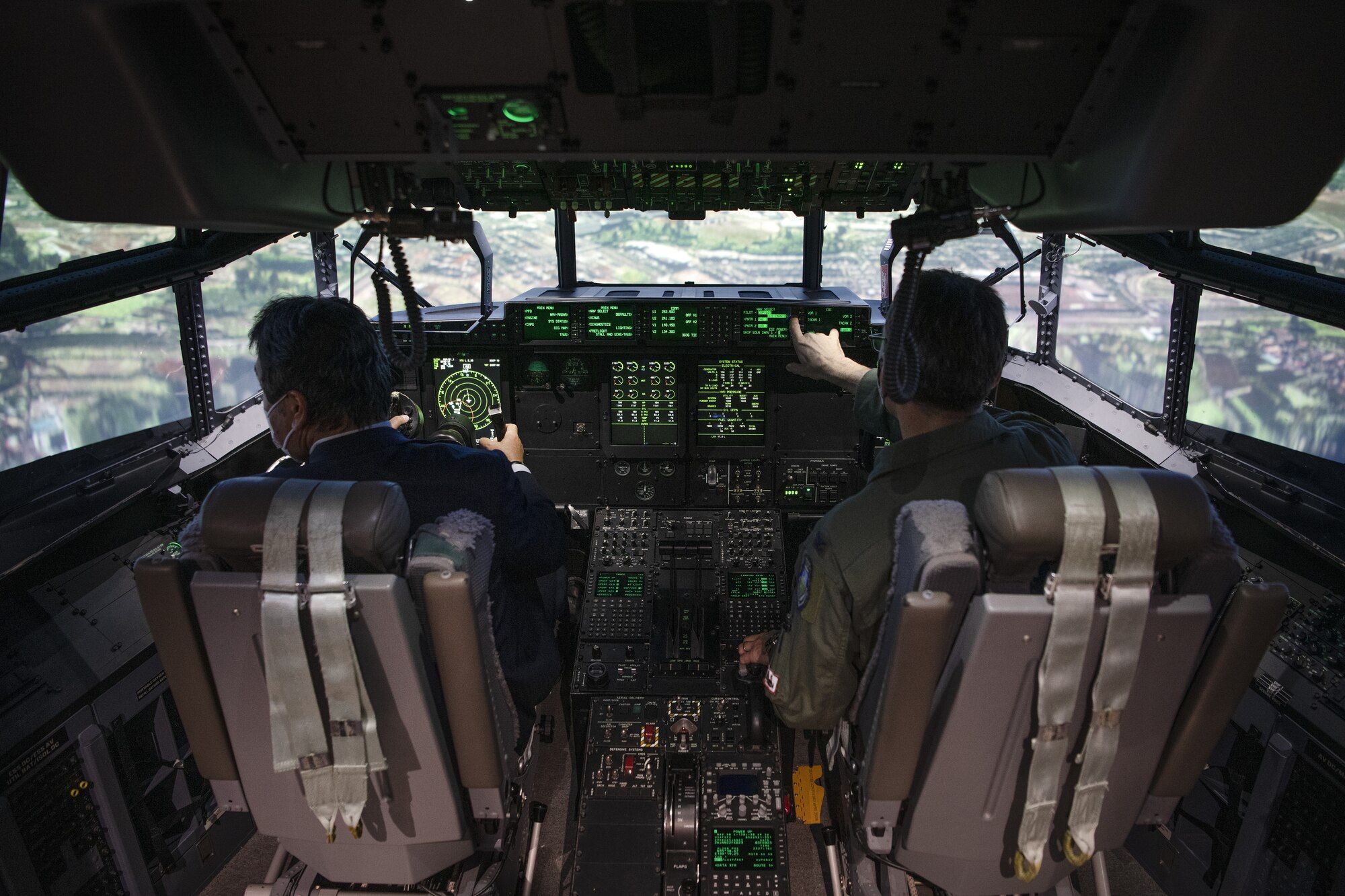 Col. Andrew Roddan, right, 374th Airlift Wing commander, helps Hiroyuki Kurihara, left, Vice Mayor of Mizuho City, Japan, pilot a C-130J Super Hercules simulator, during a community engagement event at Yokota Air Base, Japan, Feb. 3, 2023.