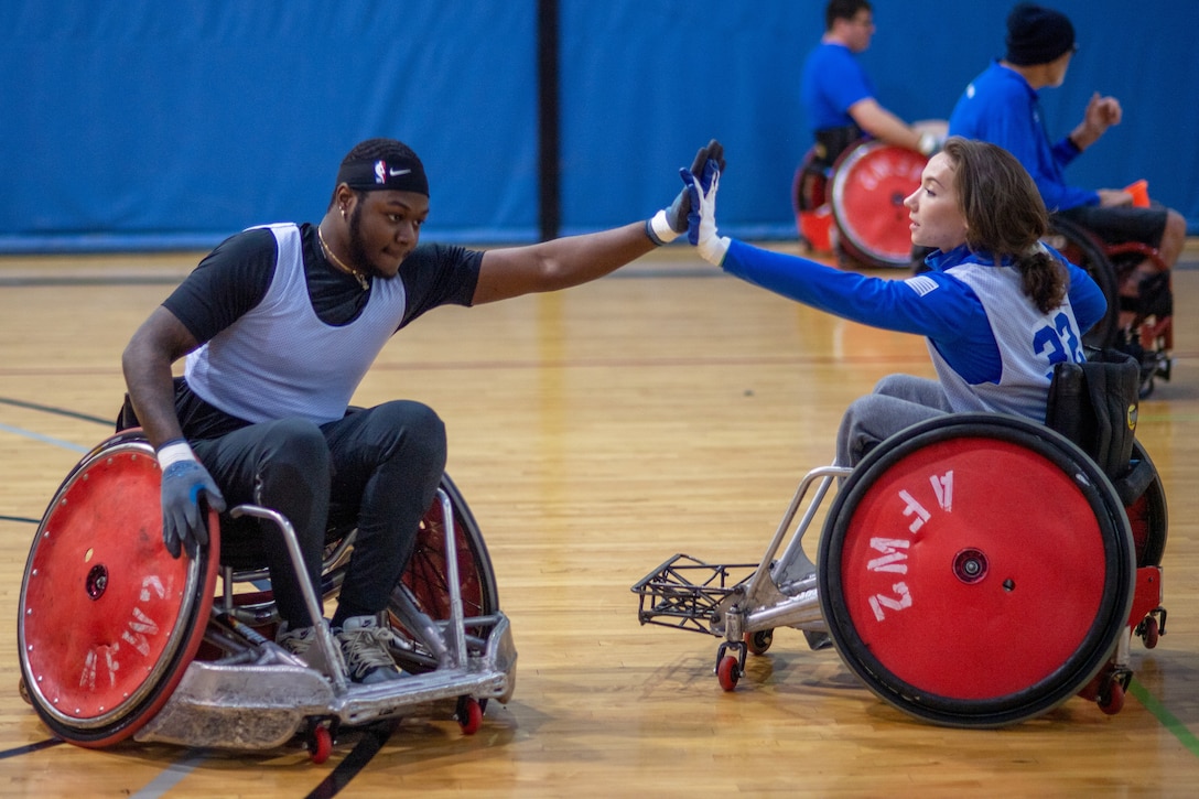 Two people in wheelchairs put each other's hands together.