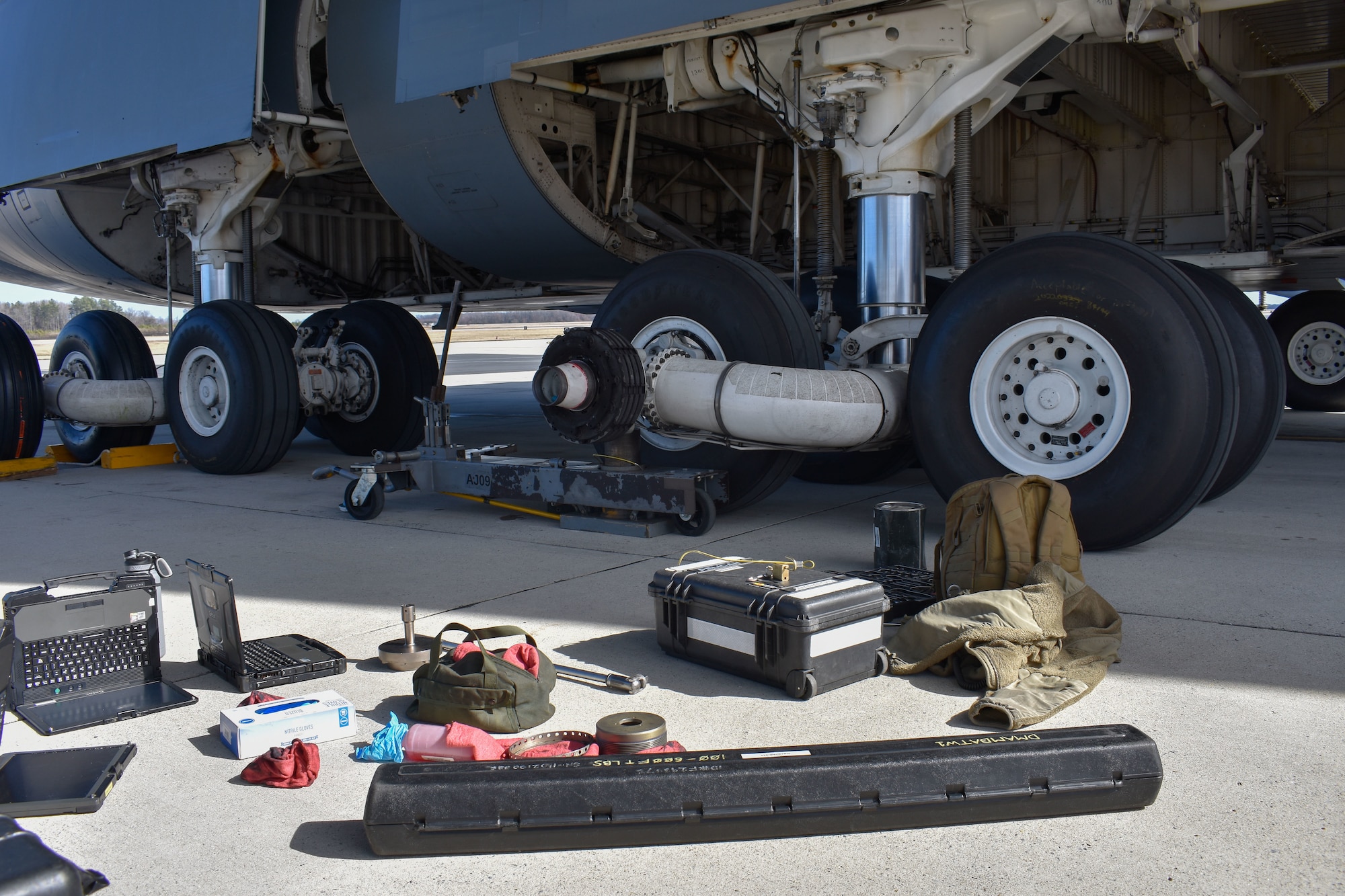 Equipment sits on the flightline on Dover Air Force Base, Delaware, before Airmen from the 436th Aircraft Maintenance Squadron change a tire on a C-5M Super Galaxy, Feb. 15, 2023. The creation of the 436th Mission Generation Group includes the 436th Logistics Readiness Squadron to better support maintenance squadrons and realign unit priorities under a mission generation culture. (U.S. Air Force photo by 2nd Lt. Jackie Noffsinger)