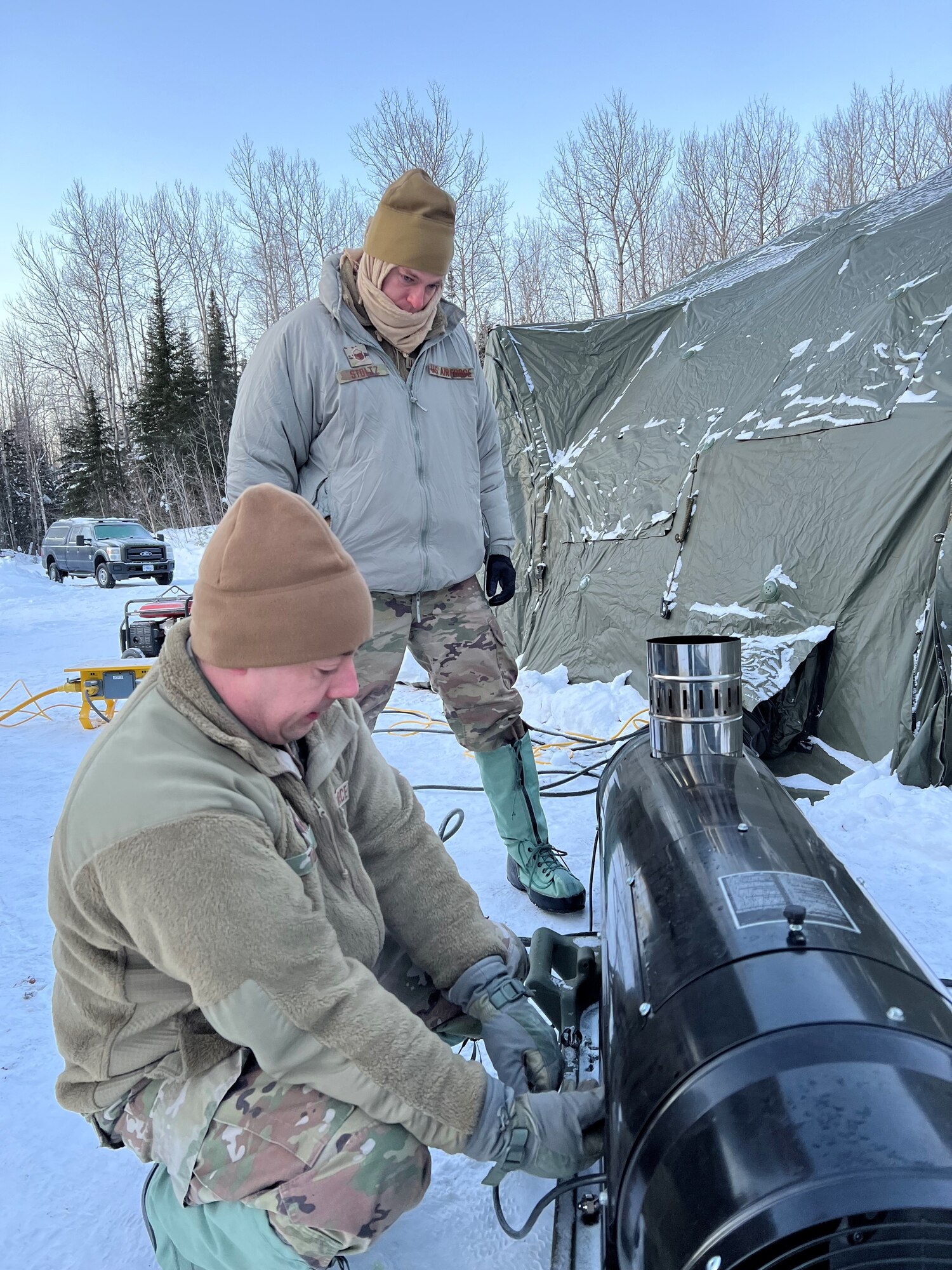Radio Frequency Transmissions specialists from the 148th Fighter Wing and 133rd Airlift Wing troubleshoot a diesel fired heater that heats work and living quarters during a winter training exercise in Northern Minnesota on January 30, 2023. Communications experts from the Minnesota National Guard, 133rd Airlift Wing and 148th Fighter Wing established a camp, including tents and communications equipment, in subzero temperatures in conjunction with the 2023 John Beargrease Sled Dog Marathon. The winter exercise allowed soldiers and airmen to set up, operationalize and troubleshoot equipment in adverse conditions in a remote location.