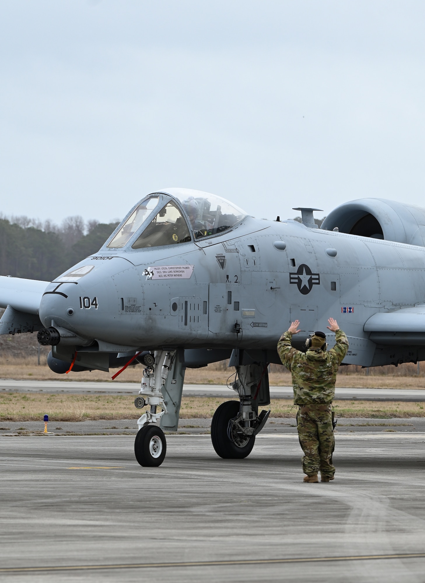 A U.S. Air Force crew chief from the 175th Aircraft Maintenance Squadron, Maryland Air National Guard, guides an A-10C Thunderbolt II aircraft on the flight line at Hunter Army Airfield, Georgia, on Jan. 25, 2023 in support of exercise Sunshine Rescue, a National Guard Bureau special focused training event.