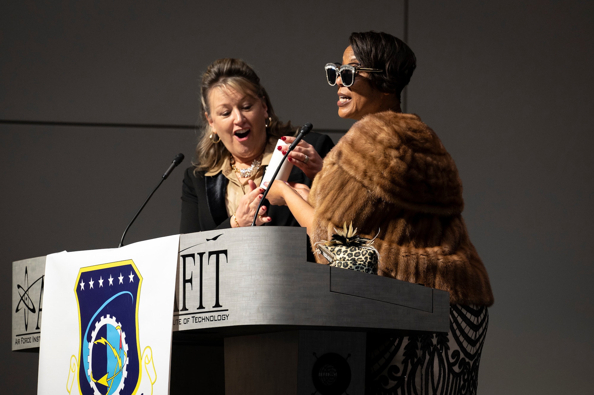 Two women standing at podium.