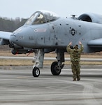 A U.S. Air Force crew chief from the 175th Aircraft Maintenance Squadron, Maryland Air National Guard, guides an A-10C Thunderbolt II aircraft on the flight line at Hunter Army Airfield, Georgia, Jan. 25, 2023, to support exercise Sunshine Rescue. The goal of the exercise is to execute traditional Combat Search and Rescue capabilities with forward-edge ground force tactics, techniques and procedures using advanced command and control technologies.