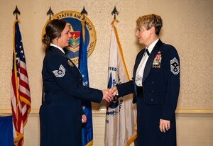 Command Chief Master Sgt. Bateman coins Tech. Sgt. Sexton.
