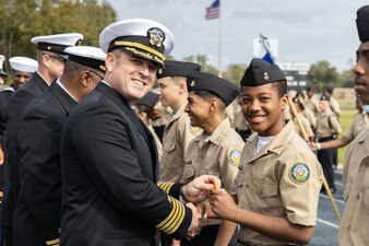 Capt. Stephen Audelo, left, Naval Education and Training Command’s (NETC) executive assistant, awards a Navy Junior Reserve Officers Training Corps student following an inspection at Booker T. Washington High School in Pensacola, Florida, Feb. 15, 2023. NETC's mission is to recruit, train and deliver those who serve our nation, taking them from street-to-fleet by transforming civilians into highly skilled, operational and combat ready warfighters. (United States Navy photo by Mass Communication Specialist 2nd Class Zachary Melvin)