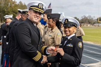 Capt. Stephen Audelo, left, Naval Education and Training Command’s (NETC) executive assistant, awards a Navy Junior Reserve Officers Training Corps student following an inspection at Booker T. Washington High School in Pensacola, Florida, Feb. 15, 2023. NETC's mission is to recruit, train and deliver those who serve our nation, taking them from street-to-fleet by transforming civilians into highly skilled, operational and combat ready warfighters. (United States Navy photo by Mass Communication Specialist 2nd Class Zachary Melvin)