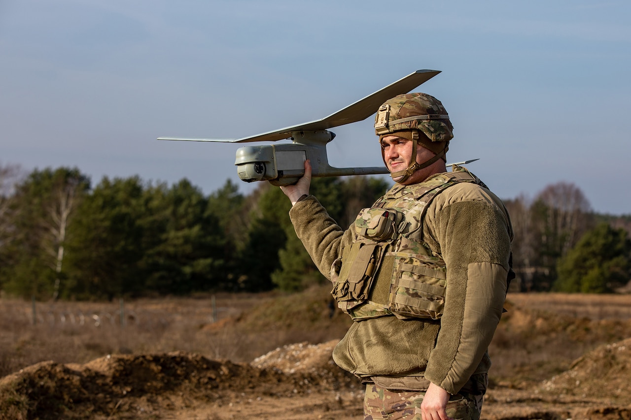 A soldier holds an aerial craft.