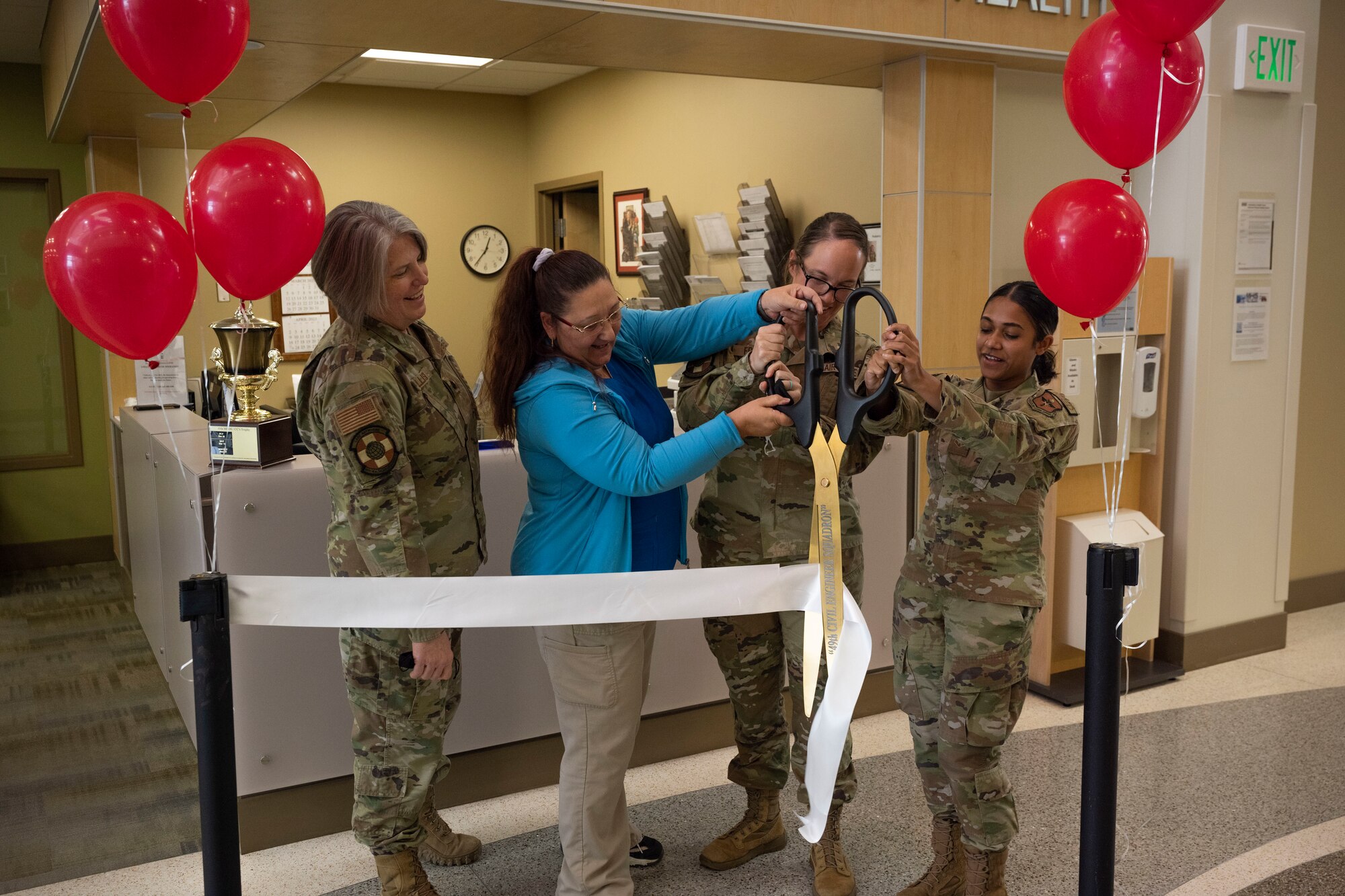 Airmen from the 49th Medical Group cut the ribbon during an opening ceremony for the Women's Health Contraceptive Clinic on Holloman Air Force Base, New Mexico, Feb. 21, 2023. The walk-in clinic will play a role in helping the female populous on base with contraceptive care, family planning and improve the overall readiness of Airmen. (U.S. Air Force photo by Senior Airman Antonio Salfran)