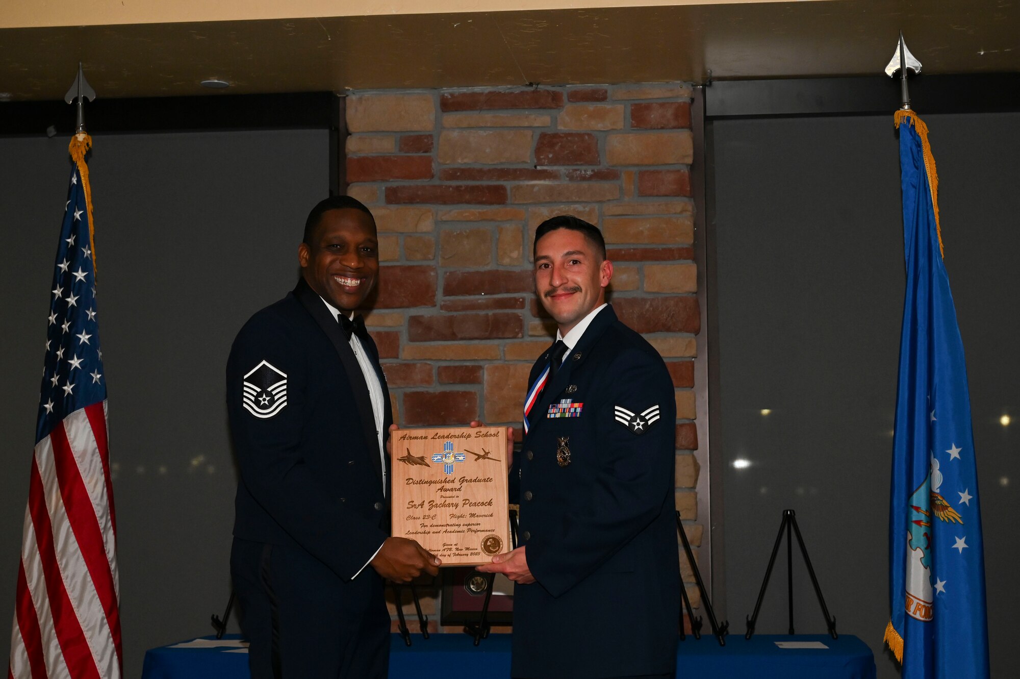 Senior Airman Zachary Peacock, 49th Civil Engineer Squadron, Airman Leadership School graduate, accepts the distinguished graduate award during the graduation of ALS class 23-C at Holloman Air Force Base, New Mexico, Feb. 16, 2023. The distinguished graduate award is presented to the top ten percent of graduates for their performance in academic evaluations and demonstration of leadership. (U.S. Air Force photo by Airman 1st Class Isaiah Pedrazzini)