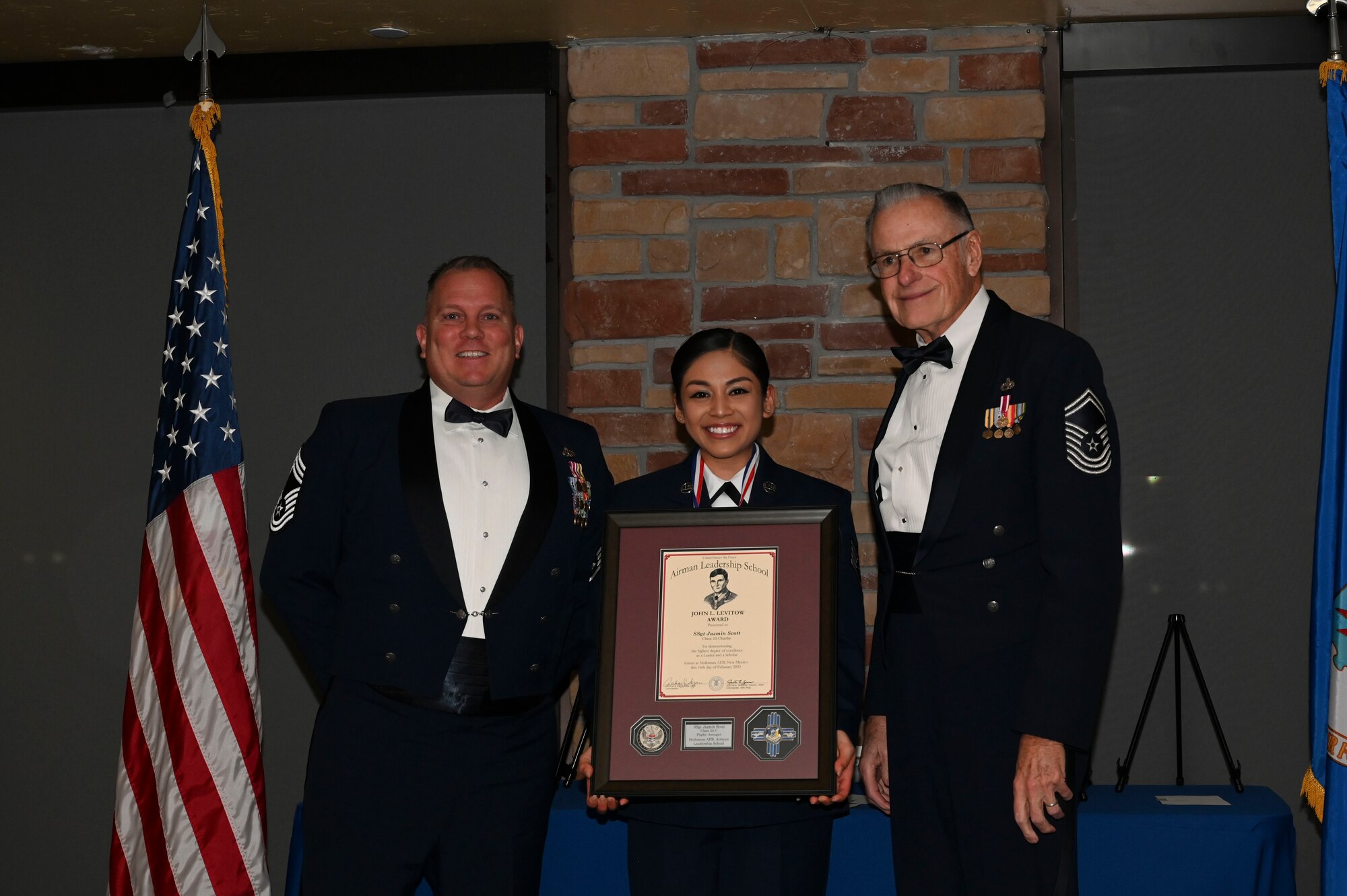 Staff Sgt. Jazmin Scott, 49th Logistics Readiness Squadron, Airman Leadership School graduate, center, accepts the John L. Levitow award during the graduation of ALS class 23-C at Holloman Air Force Base, New Mexico, Feb. 16, 2023. The John L. Levitow award is presented to the student demonstrating the highest level of leadership and scholastic performance and is partially determined by the assignment of points by their peers. (U.S. Air Force photo by Airman 1st Class Isaiah Pedrazzini)