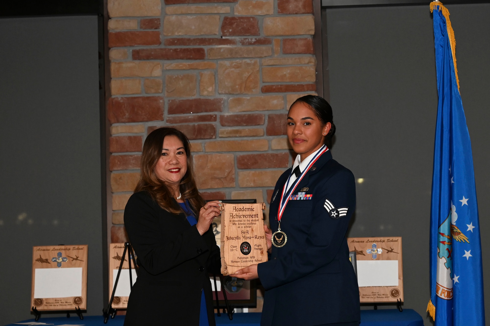 Senior Airman Johecllys Mora Reyes, 49th Security Forces Squadron, installation Airman Leadership School graduate, accepts the Academic Achievement Award during the graduation of ALS class 23-C at Holloman Air Force Base, New Mexico, Feb. 16, 2023. The academic award is presented to the student with the highest overall average on all academic evaluations and demonstrations of leadership. (U.S. Air Force photo by Airman 1st Class Isaiah Pedrazzini)