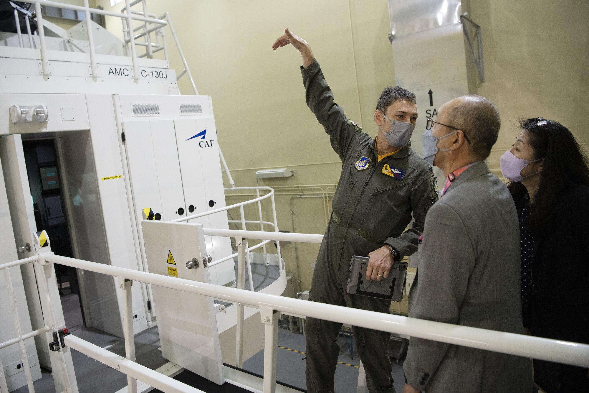 Col. Andrew Roddan, left, 374th Airlift Wing commander, and Naoko Connell, right, 374th AW community engagement specialist, explain the capabilities of the wing’s C-130J Super Hercules simulator to Jyunya Tanaka, center, Vice Mayor of Tachikawa City, Japan, during a community engagement event at Yokota Air Base, Japan, Feb. 3, 2023.