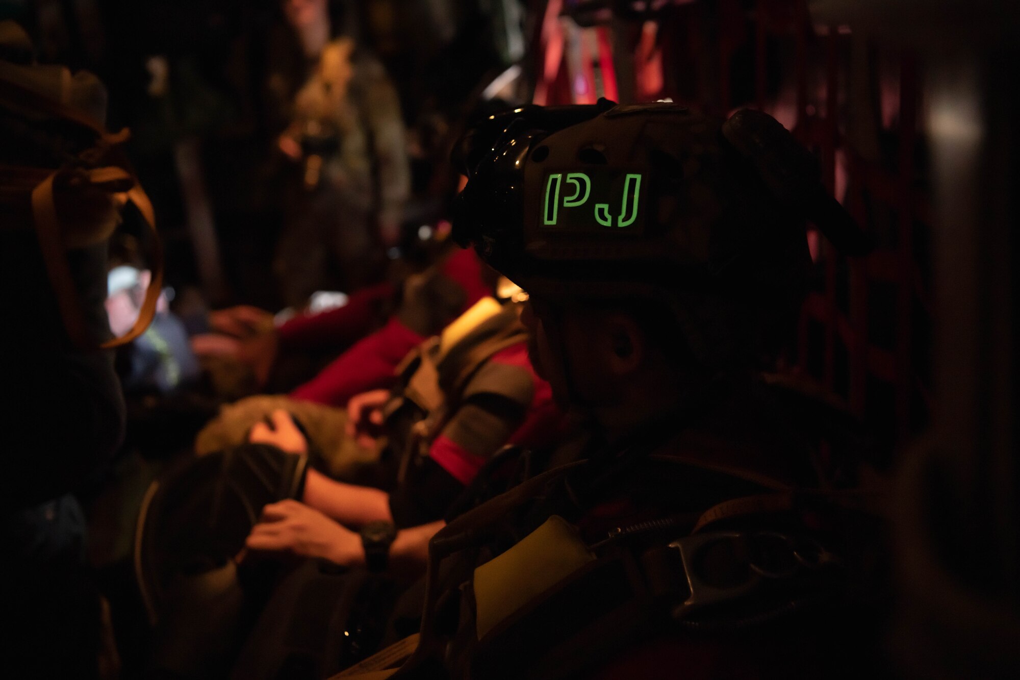 Airmen prepare to jump out of an aircraft.