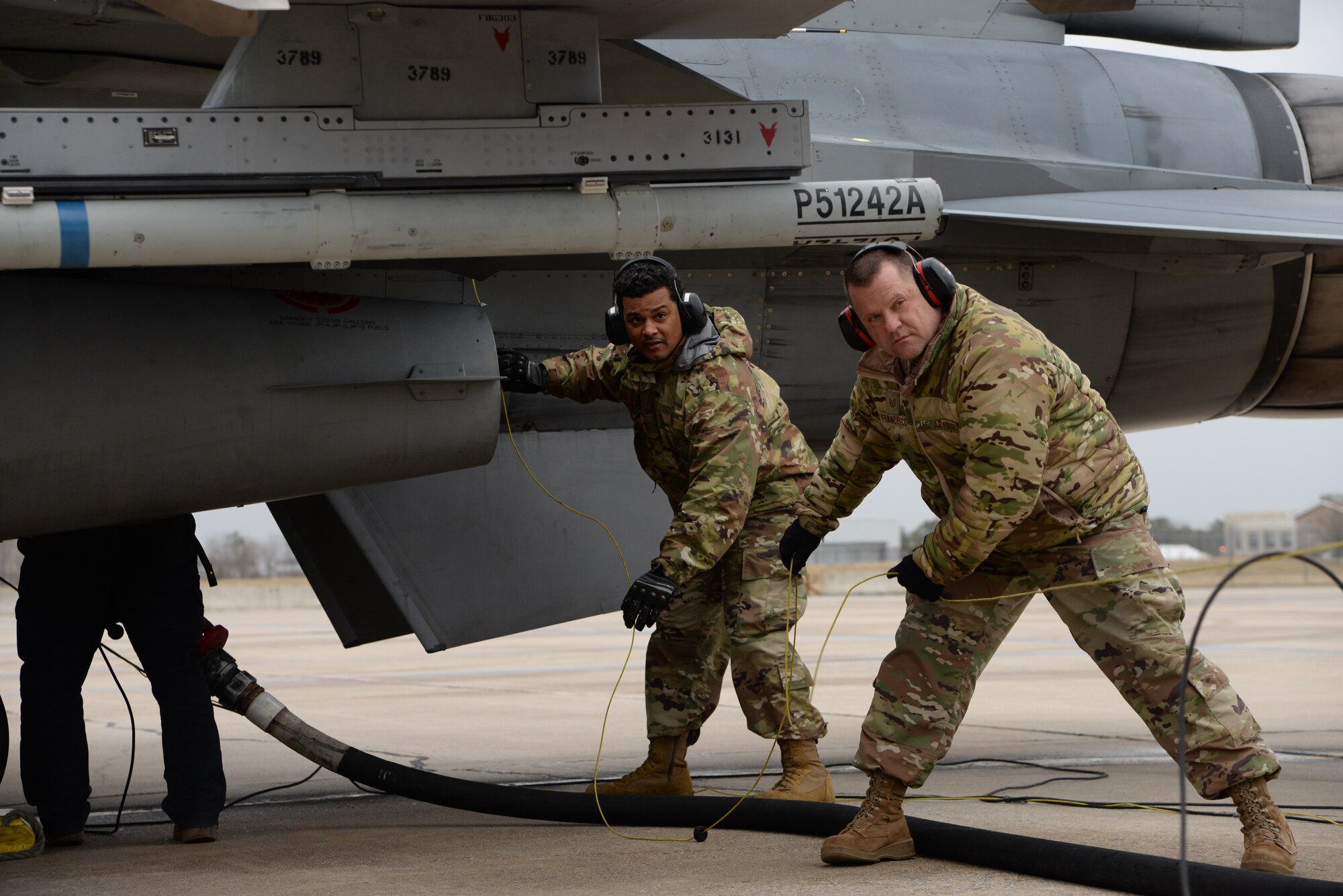 A photo of Tech. Sgt. Dominic Francesco, Sr., 177th Logistics Readiness Squadron fuels operations section chief, instructing Staff Sgt. Carmelo M. Paduani, with the 157th Civil Engineer Squadron, Pease Air National Guard Base, New Hampshire, how to perform a hot-pit refuel of an F-16C+ Fighting Falcon during an Integrated Combat Turnaround training.