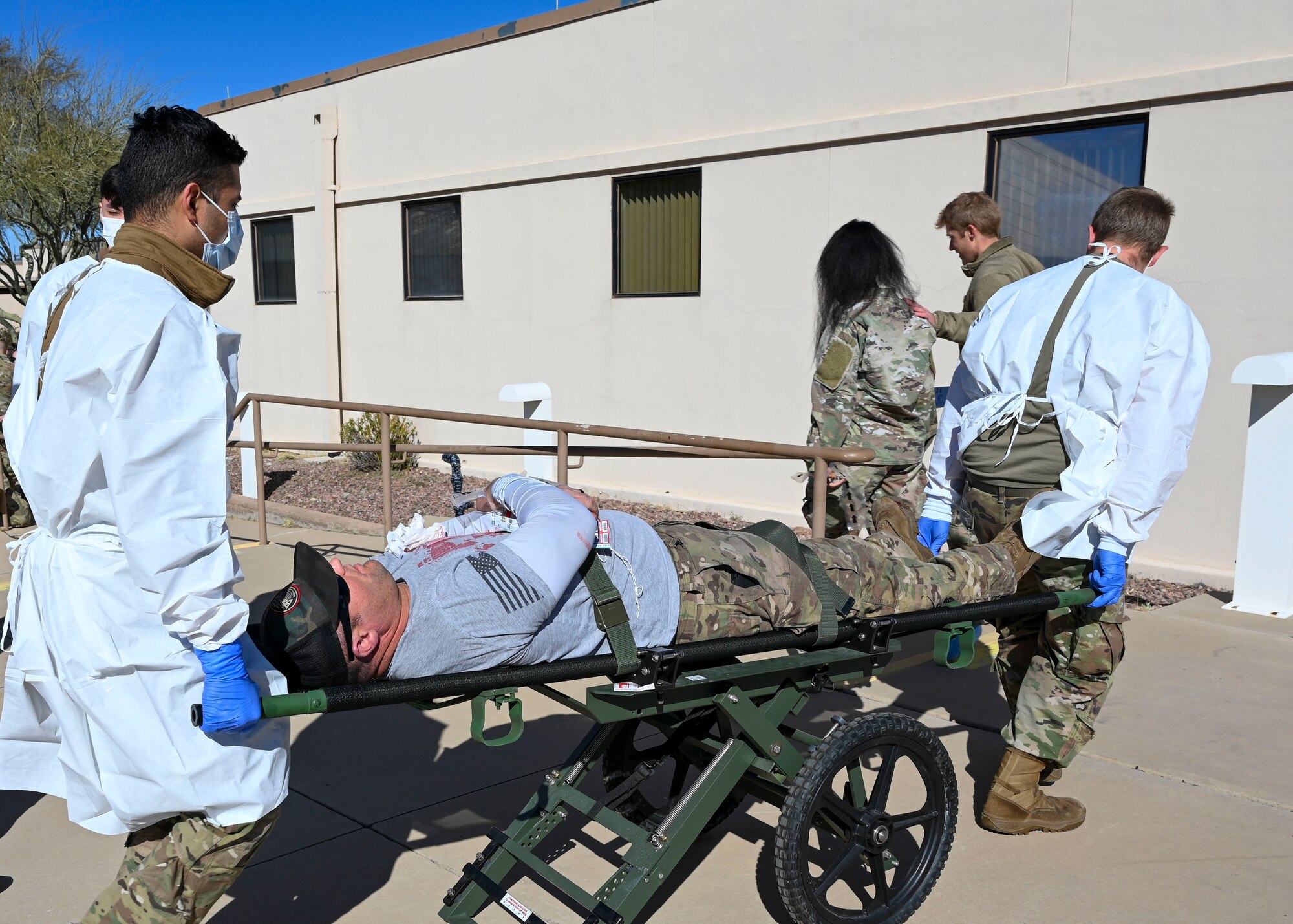 Airmen transport a simulated casualty on a stretcher during a mass casualty training exercise at Davis-Monthan Air Force Base