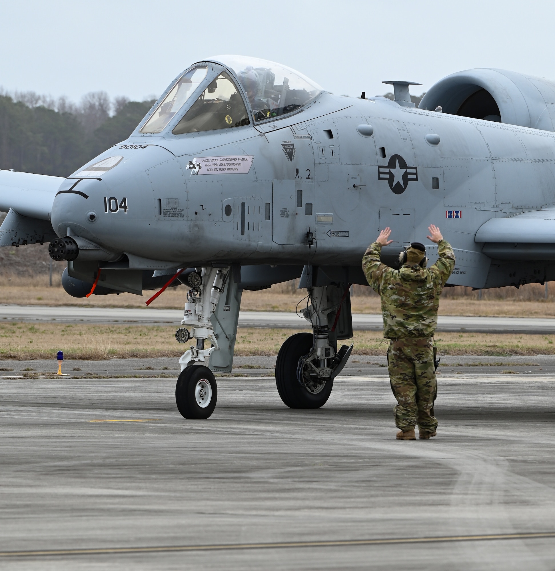 A U.S. Air Force crew chief from the 175th Aircraft Maintenance Squadron, Maryland Air National Guard, guides an A-10C Thunderbolt II aircraft on the flight line at Hunter Army Airfield, Georgia, Jan. 25, 2023, to support exercise Sunshine Rescue. The goal of the exercise is to execute traditional Combat Search and Rescue capabilities with forward-edge ground force tactics, techniques and procedures using advanced command and control technologies.