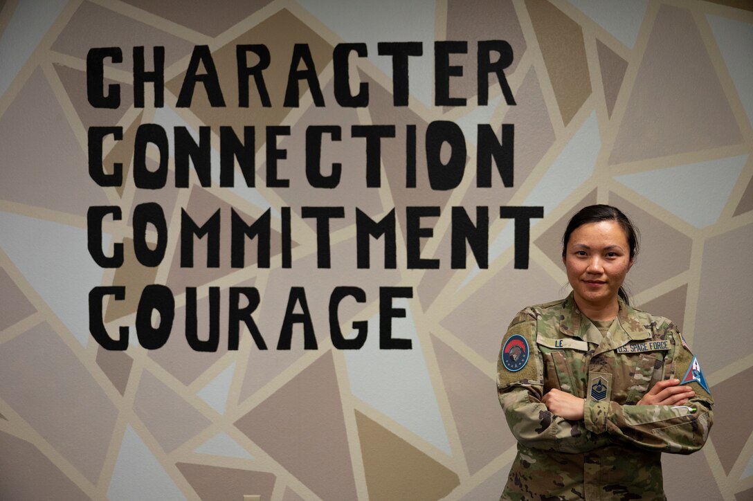 U.S. Space Force Master Sgt. Hanh Le, Detachment 1 senior enlisted leader, stands in front of the Space Force core values, at Goodfellow Air Force Base, Texas, Feb. 22, 2023. Le intentionally connects with all her Guardians, she commits to their success, and she courageously stands up for change. (U.S. Air Force photo by Senior Airman Michael Bowman)