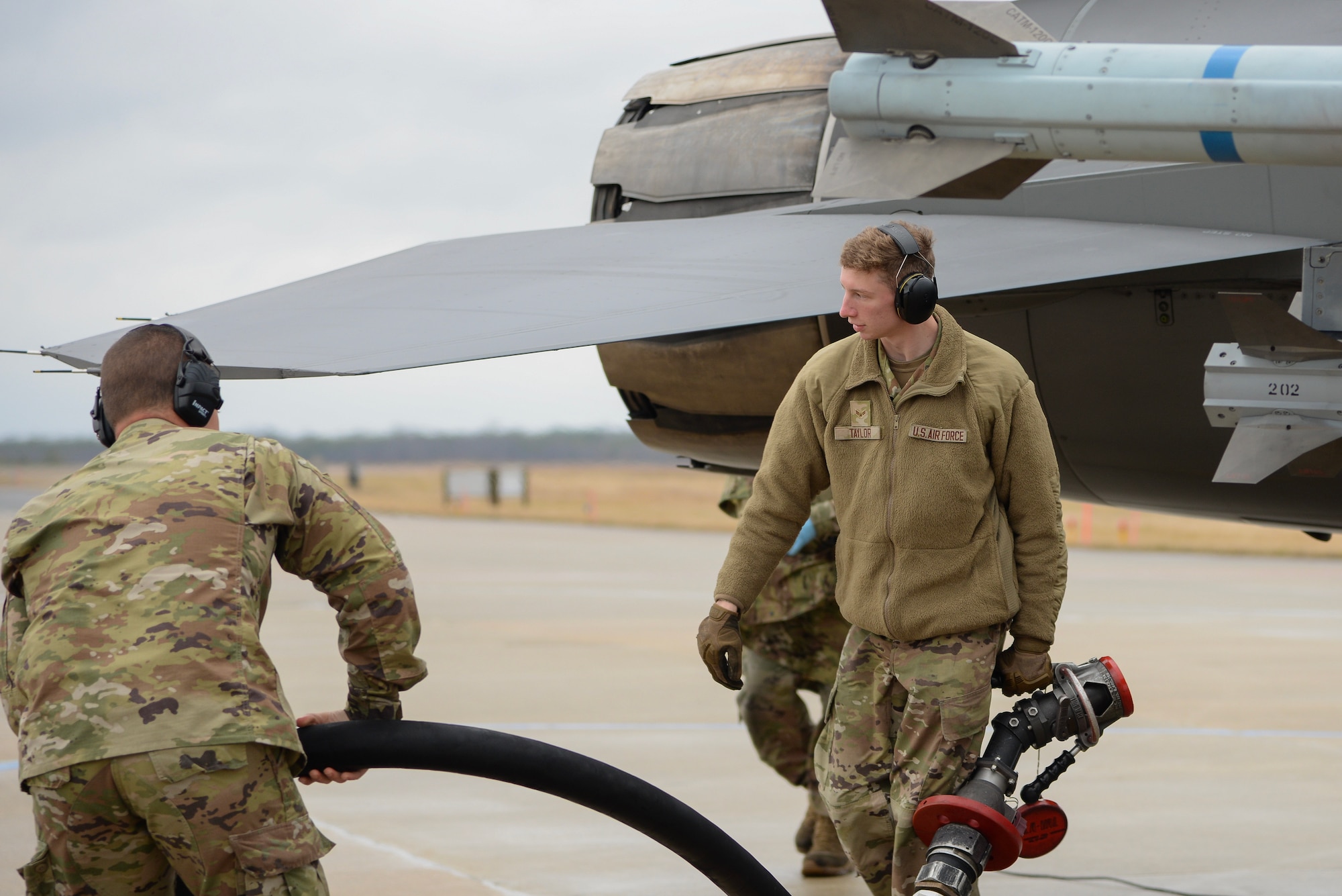 A photo of Airman 1st Class Nolan Taylor, 87th Logistics Readiness Squadron fuels service center controller, being instructed on how to perform a hot-pit refuel of an F-16C+ Fighting Falcon by Tech. Sgt. Charles A. Zingrone, Jr., 177th Logistics Readiness Squadron Fuels Management Flight fuels information service center section chief, during Integrated Combat Turnaround training.