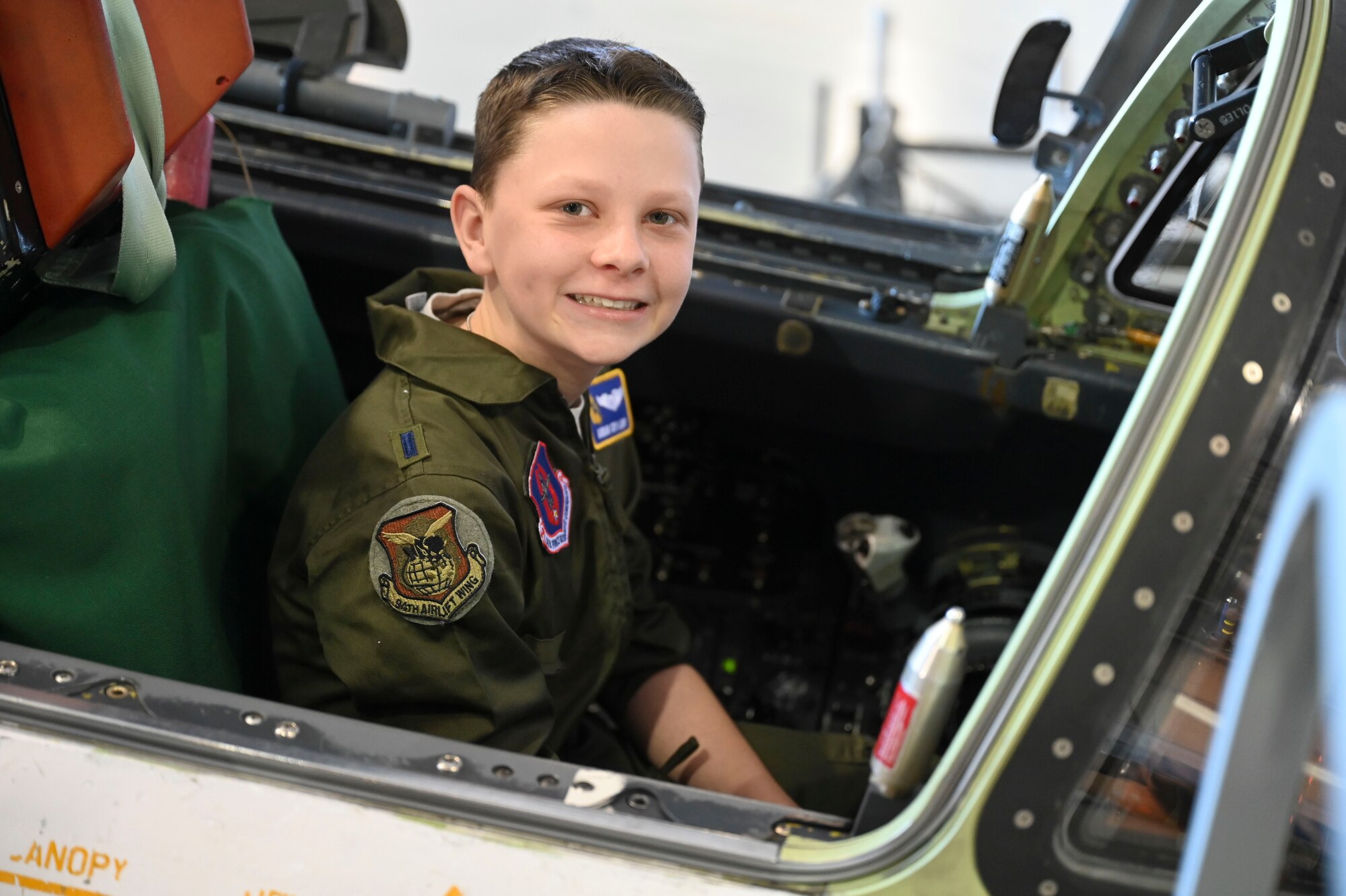 Boy looks at the camera while sitting in the cockpit of an ER-2.