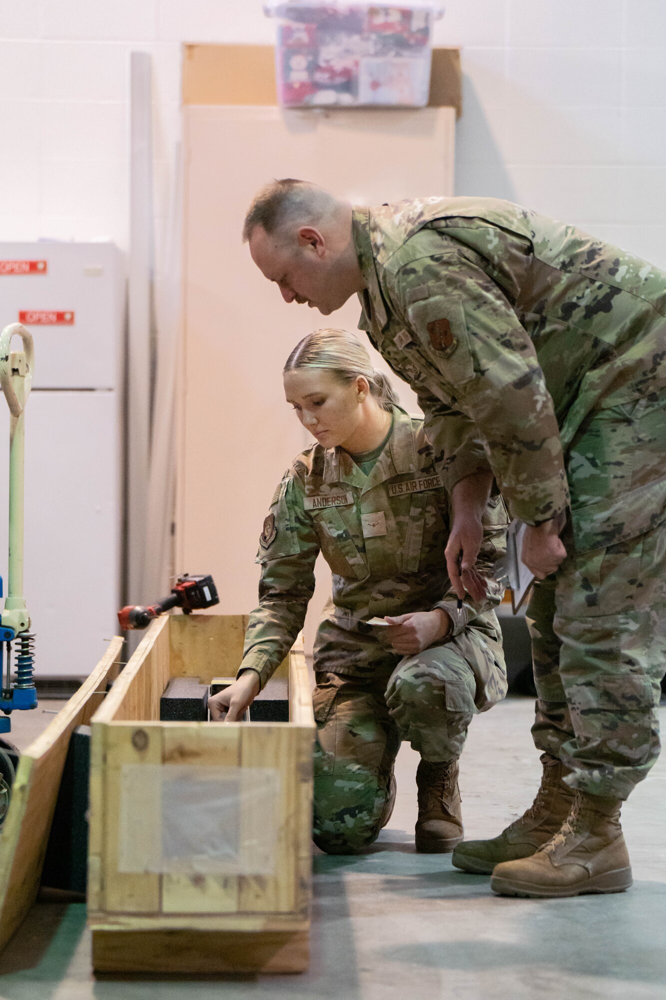 U.S. Air Force Airman 1st Class Ellie Anderson (left), customer support apprentice and Staff Sgt. Ryan McNamara, customer support craftsman (right), both assigned to the 114th Fighter Wing Logistics Readiness Squadron work together to fulfill a customer’s equipment order in the supply warehouse during a unit training assembly at Joe Foss Field, Feb. 25, 2023.