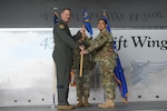 Col. Terry W. McClain, 433rd Airlift Wing commander, presents the 433rd Maintenance Group guidon to Lt. Col. Carla M. Martinez, 433rd MXG commander, during the assumption of command ceremony at Hangar 826 on Joint Base San Antonio-Lackland, Texas, Feb. 4, 2023. Martinez had been serving as the group’s acting commander since August 2021. (U.S. Air Force photo by Senior Airman Brittany Wich)