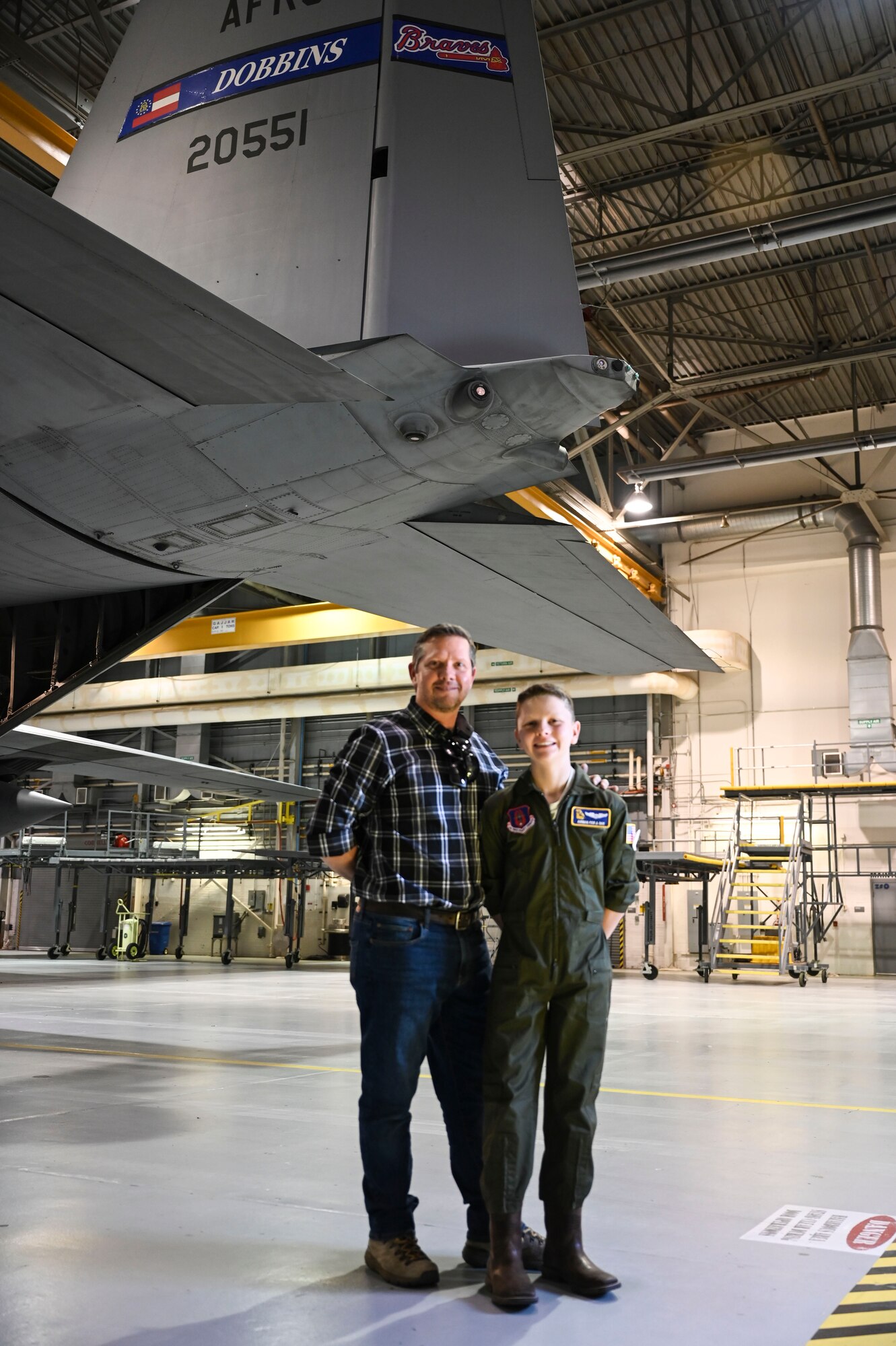 Man and boy pose for a photo in front of a C130.