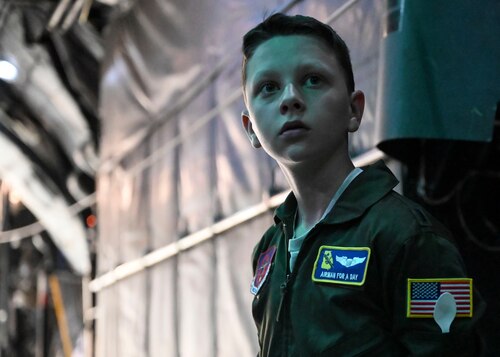 Boy looks out on the back of a C130.