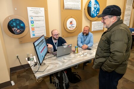 Photo of Representatives from the IMD Service Desk explaining the ticketing process to a colleague.