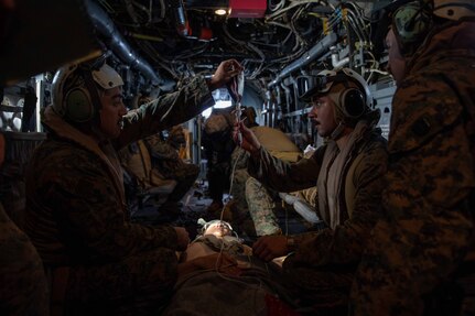 Hospital Corpsman 3rd Class Josh Mosqueda, assigned to Marine Medium Tiltrotor Squadron (VMM) 362 (Rein.), 13th Marine Expeditionary Unit (MEU), left, and 3rd Class Guillermo Salguero, assigned to Marine Fighter Attack Squadron (VMFA) 122, 13th MEU, hangs a blood bag during casualty response training in an MV-22 Osprey, assigned to VMM 362, 13th MEU, during Expeditionary Strike Force (ESF) operations with the Nimitz Carrier Strike Group (NIMCSG), Feb. 15, 2023 in the South China Sea. Nimitz Carrier Strike Group (NIMCSG) and amphibious assault ship USS Makin Island (LHD 8) with embarked 13th Marine Expeditionary Unit are conducting joint expeditionary strike force (ESF) operations, representing unique high-end war fighting capabilities, maritime superiority, and power projection, demonstrating the U.S. commitment to our allies and partners in the Indo-Pacific region. (U.S. Navy photo by Mass Communication Specialist 2nd Class Nadia Lund)